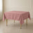 Dusty rose wrinkle-resistant square tablecloth on a dining table.