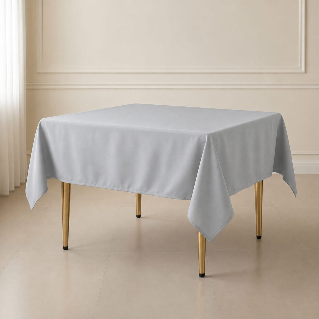 Silver wrinkle-resistant square tablecloth on a wooden table.