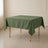 Olive green wrinkle-resistant square tablecloth on a dining table.
