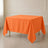 Orange wrinkle-resistant polyester square tablecloth on a dining table.