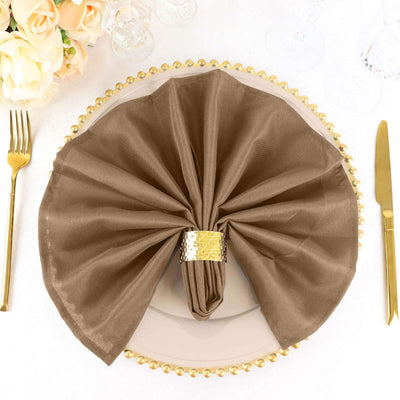 Elegant brown napkin elegantly folded on a decorative plate with gold accents.