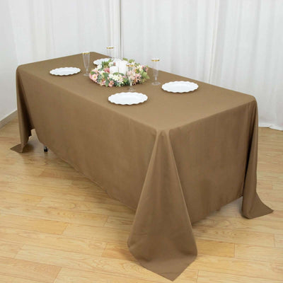 Brown tablecloth draped over a table set for an elegant gathering.