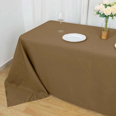 Brown tablecloth draped over a table with a plate and glass