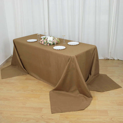 Brown tablecloth draped elegantly over a table with floral centerpiece and plates.