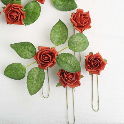 Artificial red roses with green leaves on a white background.
