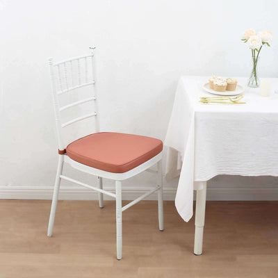 White chiavari chair with a pink cushion next to a table setting.