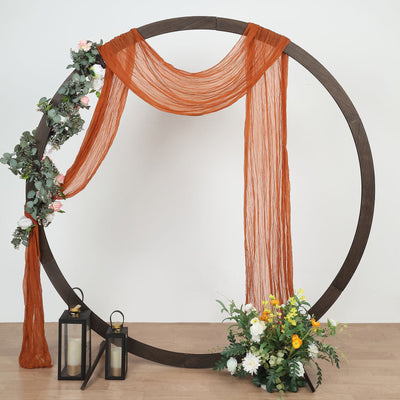 Decorative circular backdrop with draped fabric, lanterns, and flowers.
