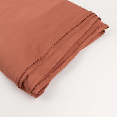 Folded terracotta fabric on a plain background.