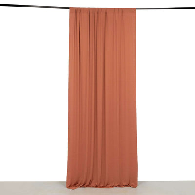 Rust-colored curtain hanging on a rod against a plain white background