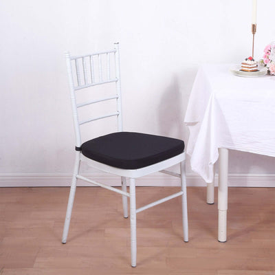 White chiavari chair with black cushion beside a table