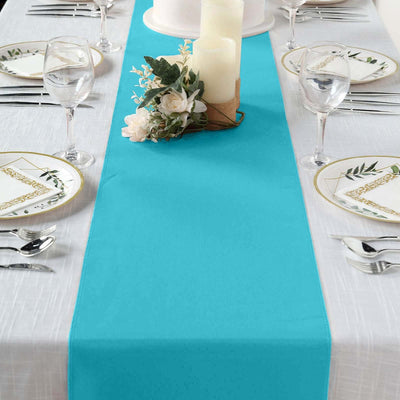 Turquoise table runner on a dining table set for a meal with floral decor.