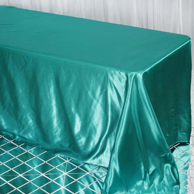 Teal satin tablecloth draped over a table.