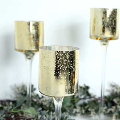 Gold mercury glass candle holders in a decorative setting.