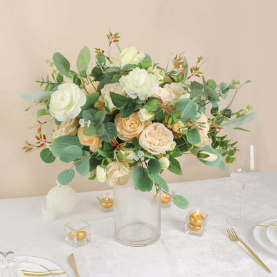 Elegant floral arrangement in a glass vase with soft peach and white blooms.