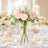 Elegant wedding centerpiece with pink and white roses in a glass vase