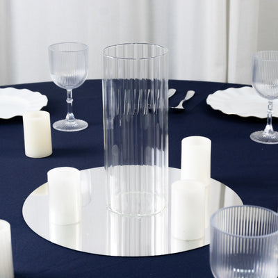 Clear glass vase with ribbed design on a table setting.