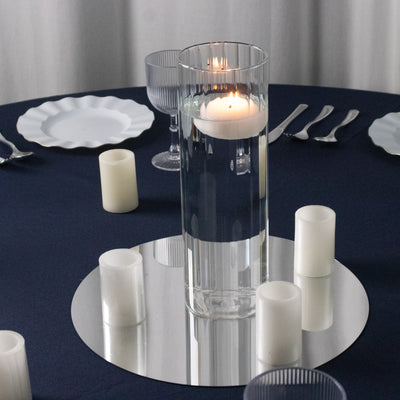 Elegant centerpiece with floating candle and glass vase on a dining table.