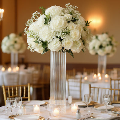 Elegant white floral centerpiece in a tall glass vase for event table decor.