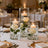 Elegant floral centerpieces with candles and roses at a wedding reception.
