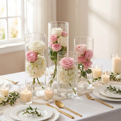 Elegant rose centerpiece in glass vases with candles and gold table settings