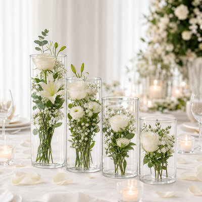 Elegant white floral wedding centerpieces in glass cylinder vases with candles