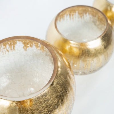 Gold and clear glass vases in a row showcasing elegant design.