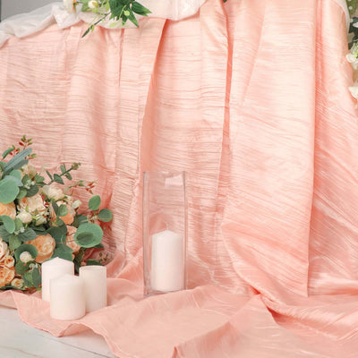 Peach-colored fabric draped with candles and floral arrangements.