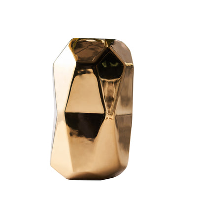 Geometric gold vase with a shiny finish on a plain background