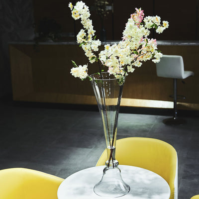 Elegant glass vase with artificial flowers on a table