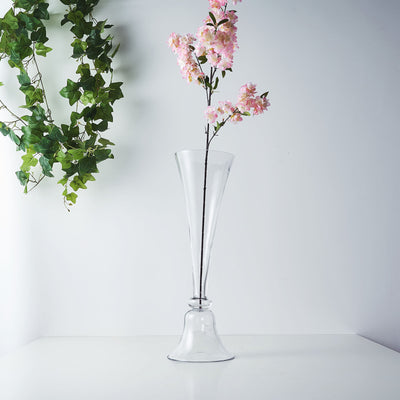 Clear glass vase with pink flowers against a plain background