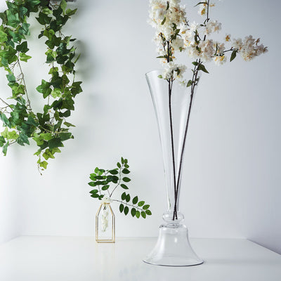 Elegant glass vase with flowers on a minimalist tabletop.