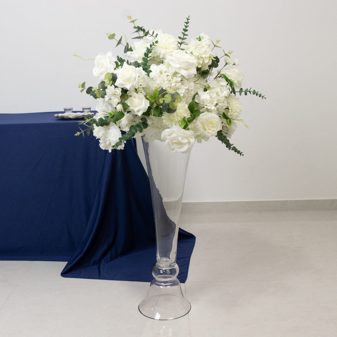 Elegant white floral arrangement in a tall glass vase.