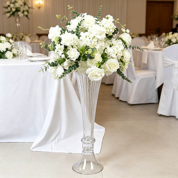 White wedding floral centerpiece in tall glass vase on banquet table