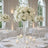 Elegant white floral wedding centerpiece in a bright reception hall