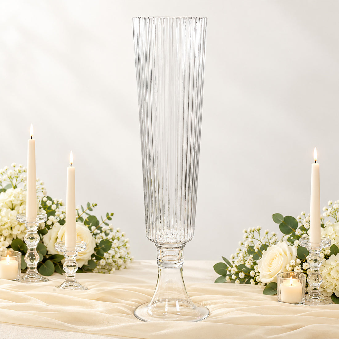 Elegant clear glass vase centerpiece with candles and white floral arrangement