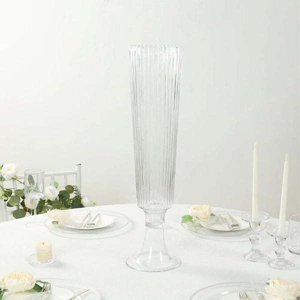 Elegant tall glass vase with ribbed design on a dining table