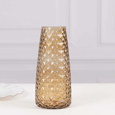 Amber geometric vase with textured surface on a light background.