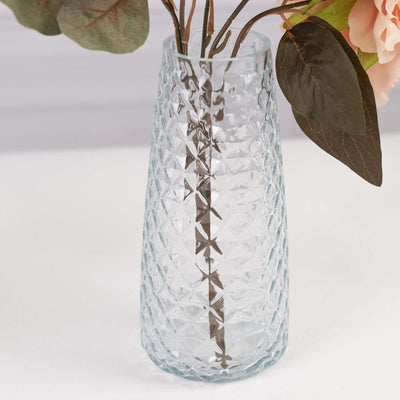 Textured blue glass vase with faux flowers.
