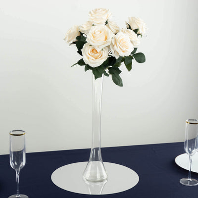Elegant white roses in a tall glass vase for table decor.