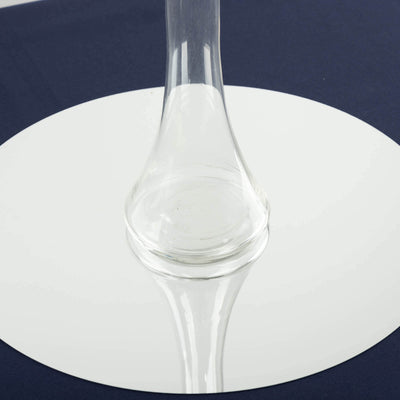 Clear glass vase on a reflective surface.