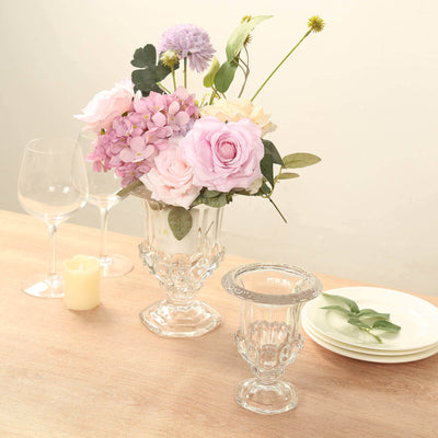 Elegant glass vase with mixed flowers and table setting for a stylish dining scene.