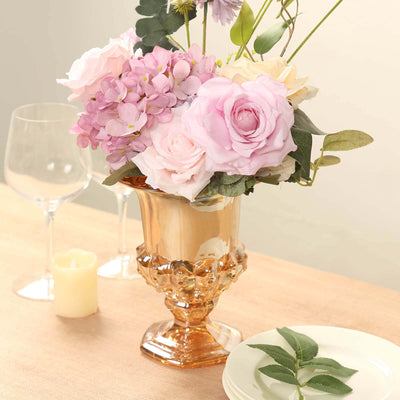 Elegant floral arrangement in a golden vase on a dining table.