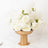 Elegant white rose arrangement in a gold vase on a marble surface.