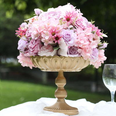 Elegant floral arrangement in a gold pedestal vase with pink and purple flowers.