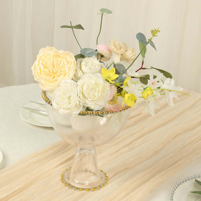 Elegant floral arrangement in a glass vase with decorative beads.