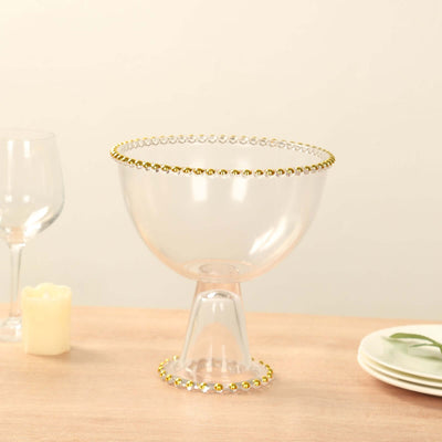 Clear glass bowl with gold beaded rim on a table setting.