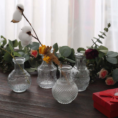 Decorative glass vases with flowers on a wooden table.
