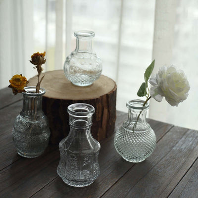 Decorative glass vases with flowers on a wooden table.