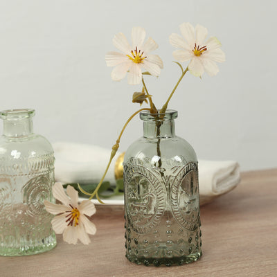 Vintage glass vase with flowers on a wooden table.