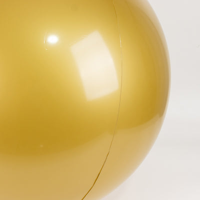 Gold beach ball with a glossy finish, showing surface reflection.